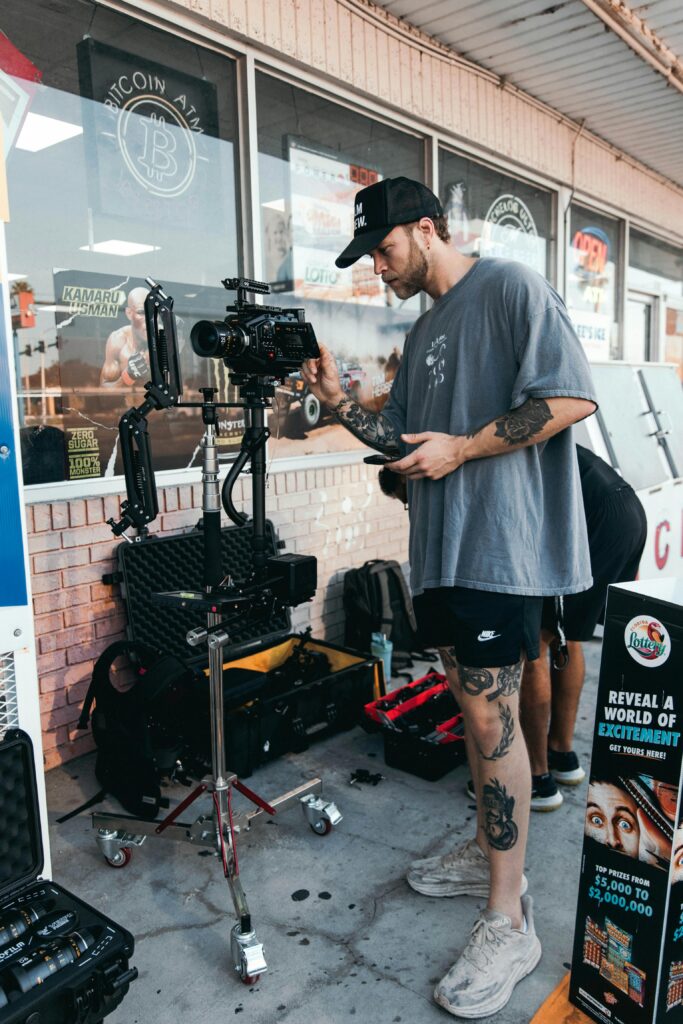 pexels-photo-18015187-18015187-1 Videographer setting up camera gear outside a shop, capturing a scene.
